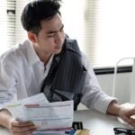 man calculates the debt at hand with a calculator.