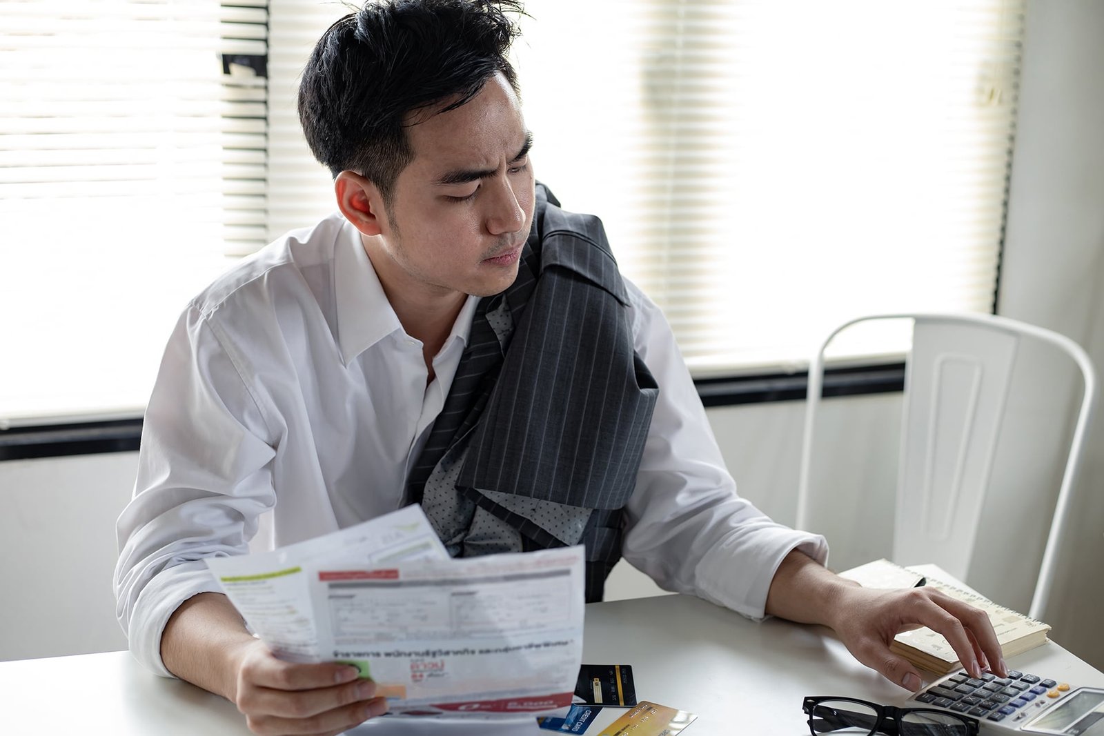 man calculates the debt at hand with a calculator.