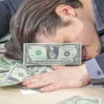 young businessman working from his office and counting cash money joy concept