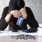 a young woman with a credit card debt and many bills placed on t