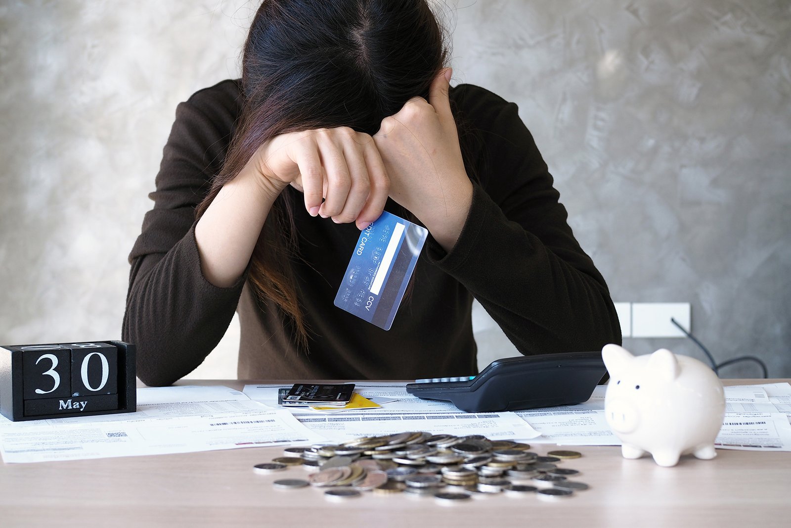 a young woman with a credit card debt and many bills placed on t
